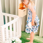 Child checking letter box on cubby house for mail